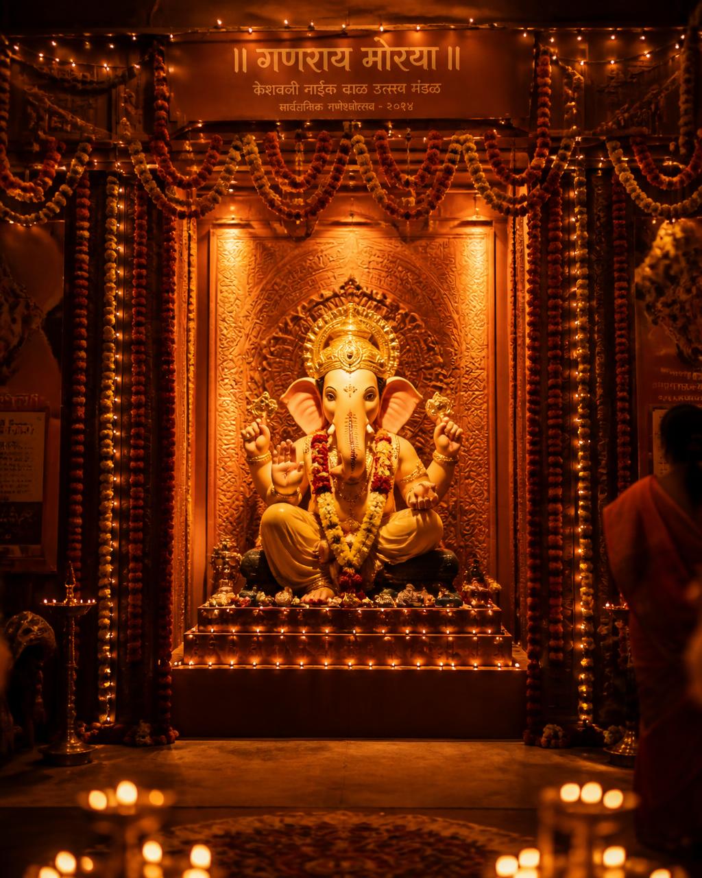 Ganesh pandal at dusk glowing with marigold garlands and string lights